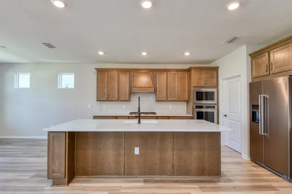 a large kitchen with granite countertop a large counter top stainless steel appliances and cabinets