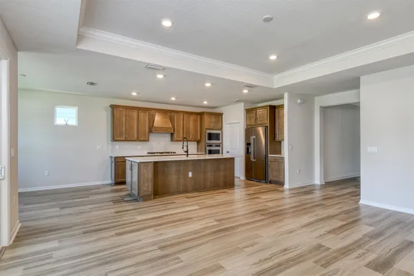 a large kitchen with stainless steel appliances granite countertop a large counter top and wooden floors