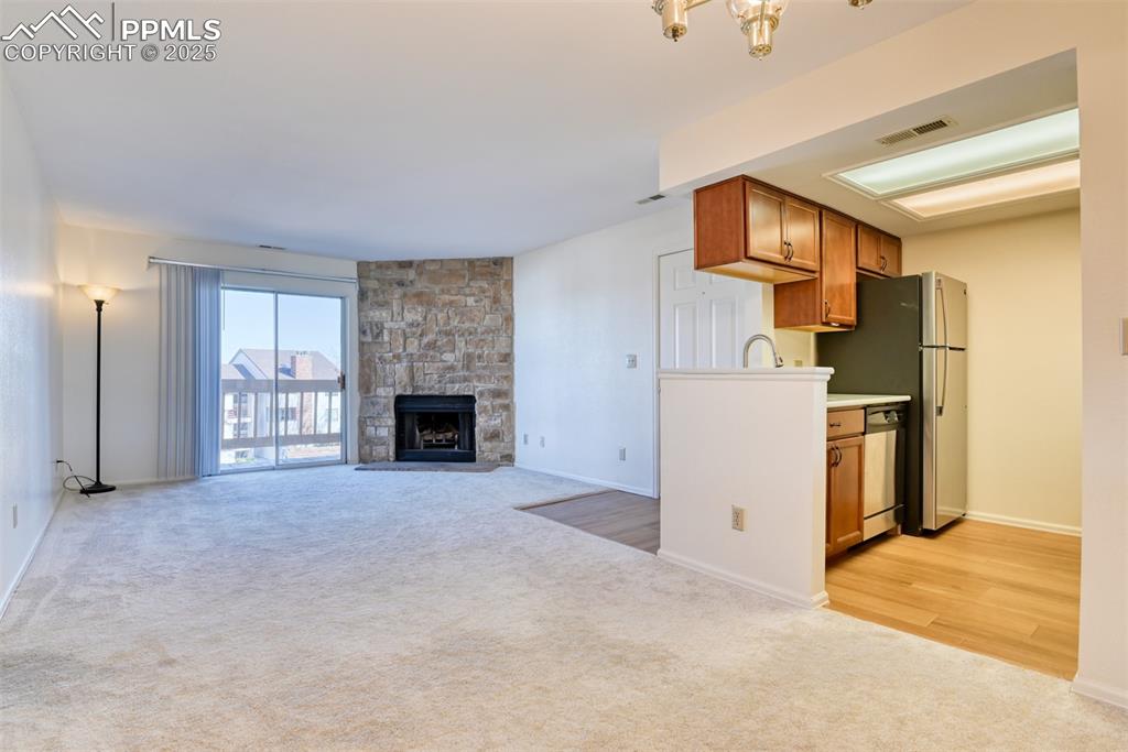 916 Tenderfoot Hill Road, Unit 101 Colorado Springs, CO 80906 - Photo 11 of 42 a view of a kitchen with a sink a refrigerator and a fireplace