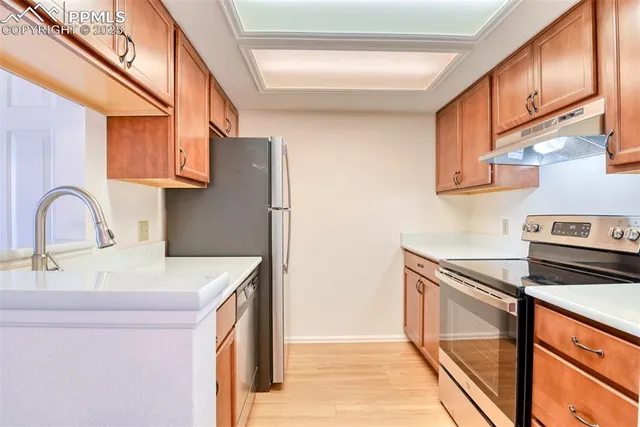 a kitchen with stainless steel appliances granite countertop a sink a refrigerator and a cabinets