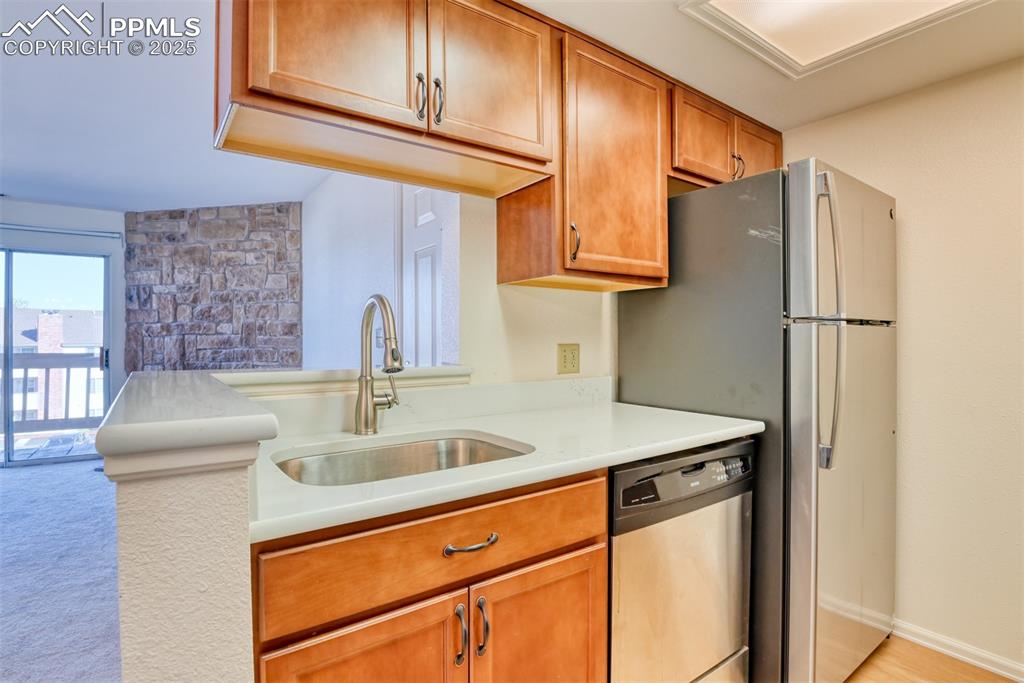 916 Tenderfoot Hill Road, Unit 101 Colorado Springs, CO 80906 - Photo 15 of 42 a kitchen with stainless steel appliances granite countertop a sink a refrigerator and a cabinets