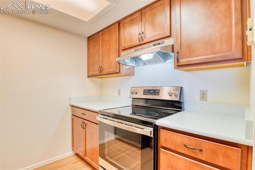 916 Tenderfoot Hill Road, Unit 101 Colorado Springs, CO 80906 - Photo 16 of 42 a kitchen with wooden cabinets and a stove top oven