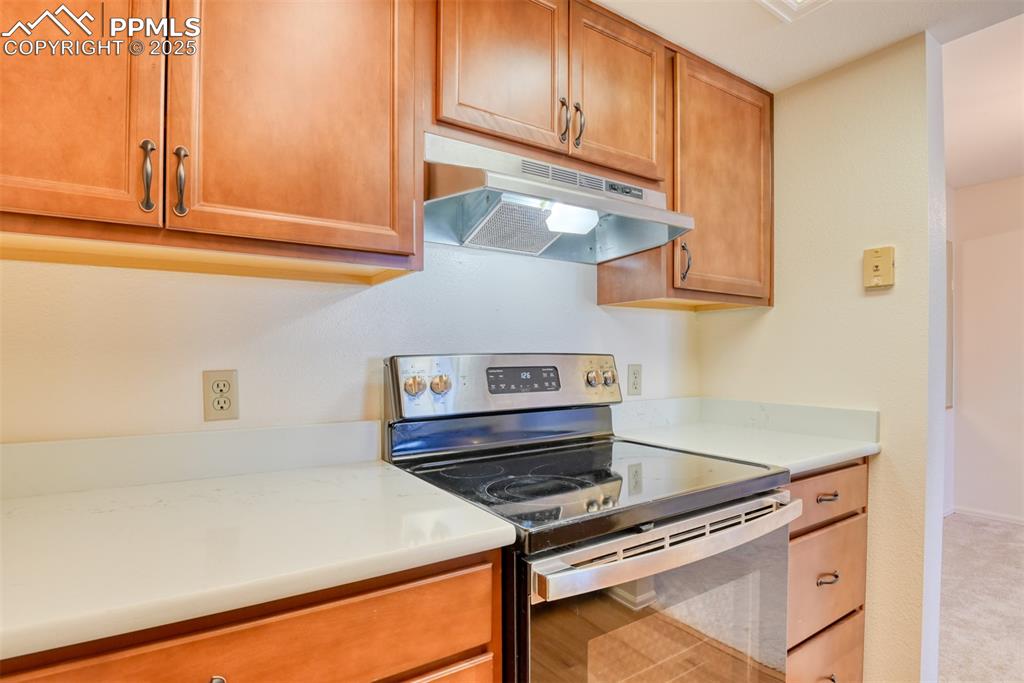 916 Tenderfoot Hill Road, Unit 101 Colorado Springs, CO 80906 - Photo 18 of 42 a kitchen with stainless steel appliances granite countertop a stove a sink and a microwave