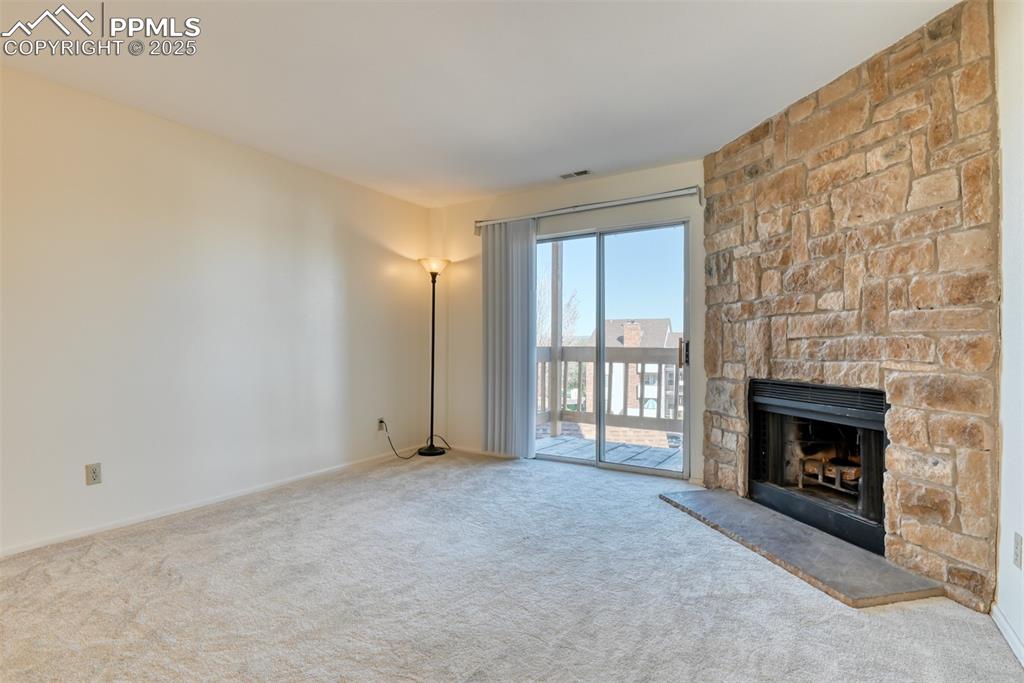 916 Tenderfoot Hill Road, Unit 101 Colorado Springs, CO 80906 - Photo 5 of 42 a view of an empty room with a fireplace and a window