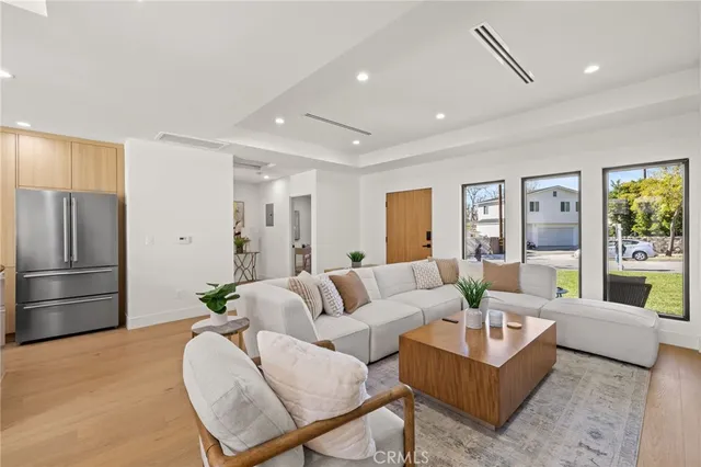 a living room with furniture and a refrigerator