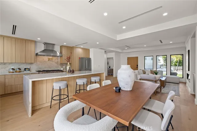 a kitchen with stainless steel appliances granite countertop a kitchen island a table and chairs in it