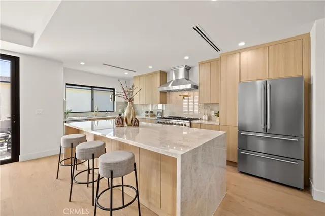 a kitchen with refrigerator a chair and wooden floor