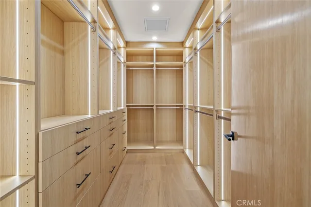 a view of walk in closet with empty racks