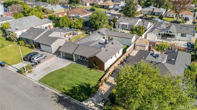 an aerial view of residential houses with outdoor space and trees
