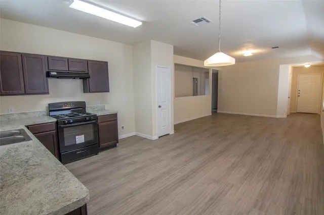 a kitchen with stainless steel appliances granite countertop a stove a sink and a refrigerator