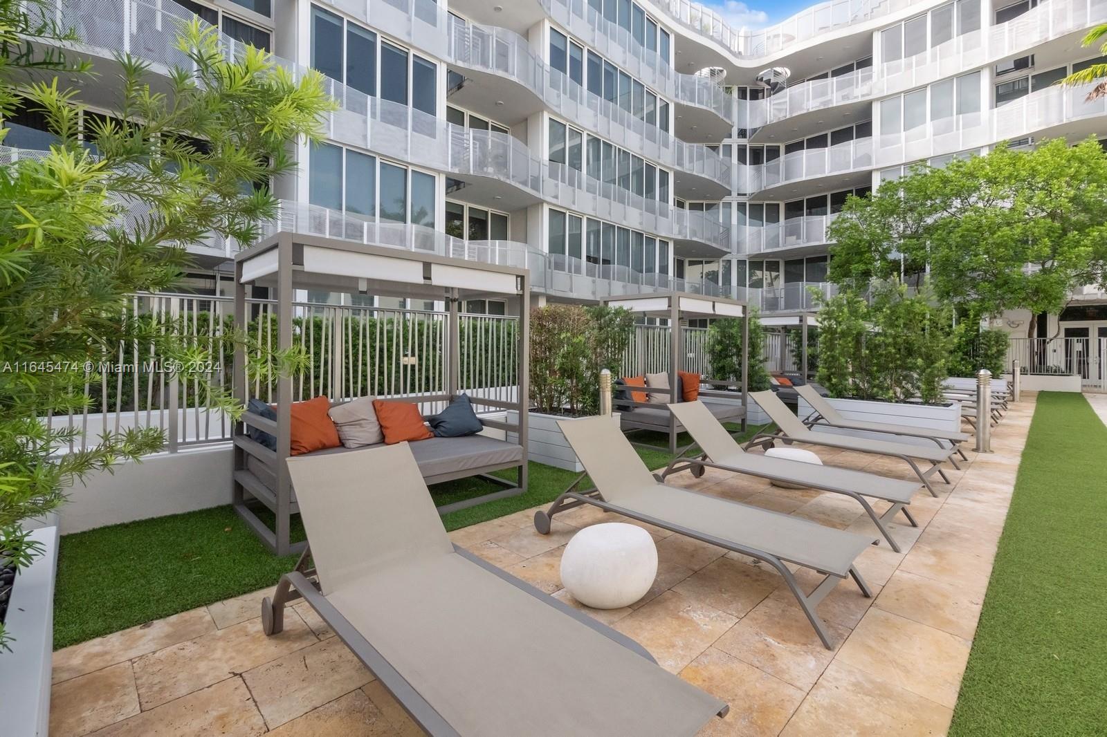 435 21st Street, Unit 310 Miami Beach, FL 33139 - Photo 20 of 28 a view of a patio with couches table and chairs and potted plants