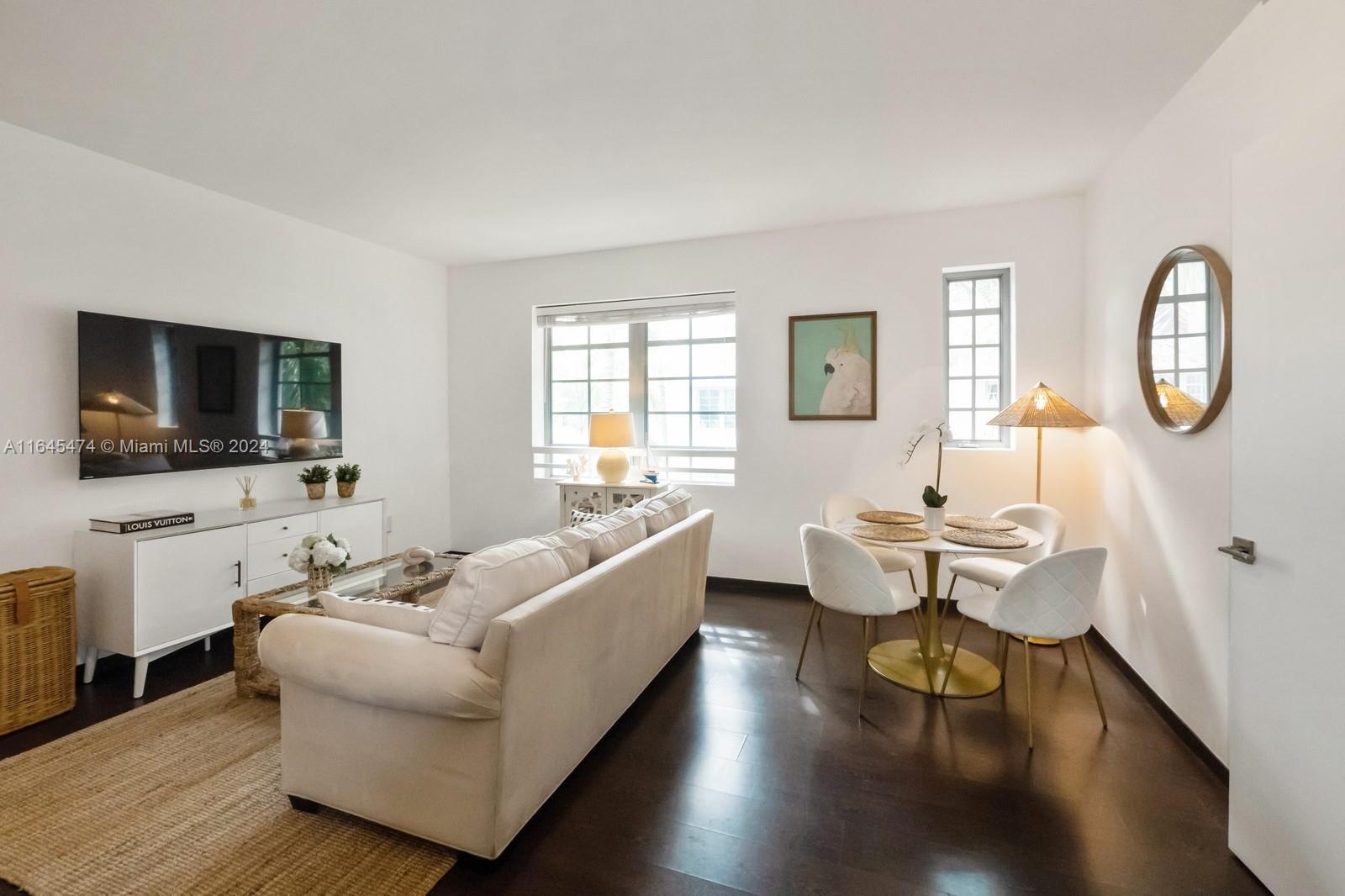 435 21st Street, Unit 310 Miami Beach, FL 33139 - Photo 2 of 28 a living room with furniture wooden floor and a flat screen tv