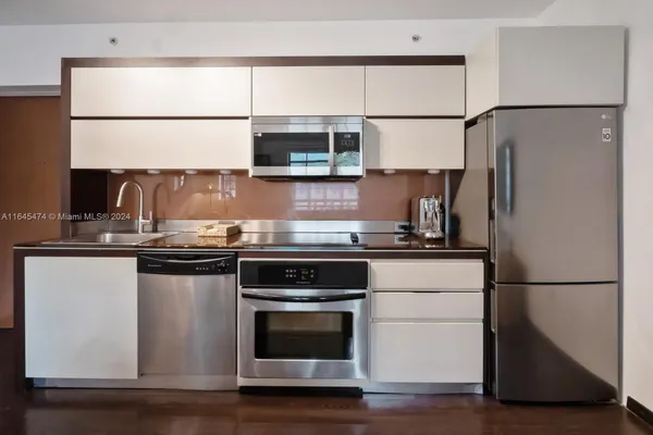 a kitchen with stainless steel appliances granite countertop a refrigerator and a stove