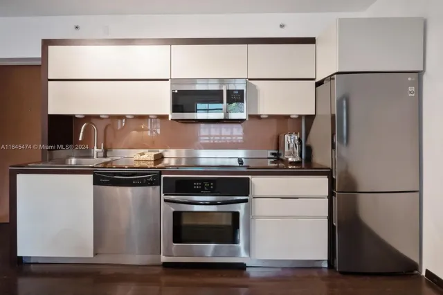 a kitchen with stainless steel appliances granite countertop a refrigerator and a stove
