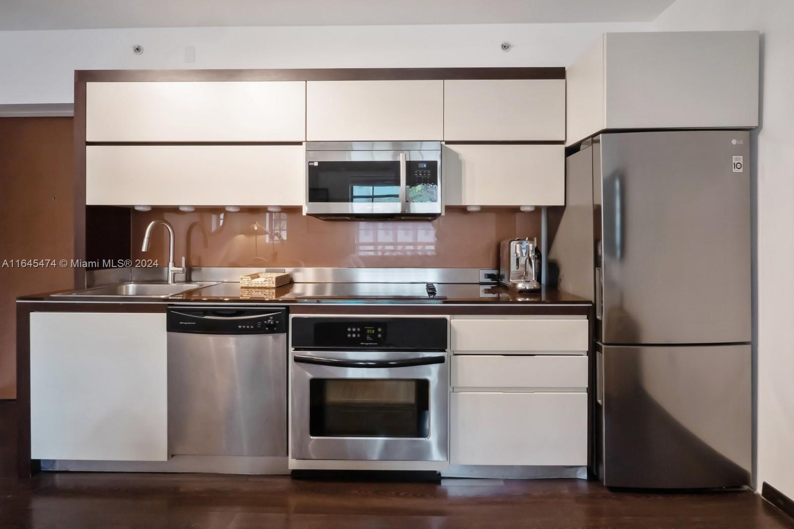 435 21st Street, Unit 310 Miami Beach, FL 33139 - Photo 5 of 28 a kitchen with stainless steel appliances granite countertop a refrigerator and a stove