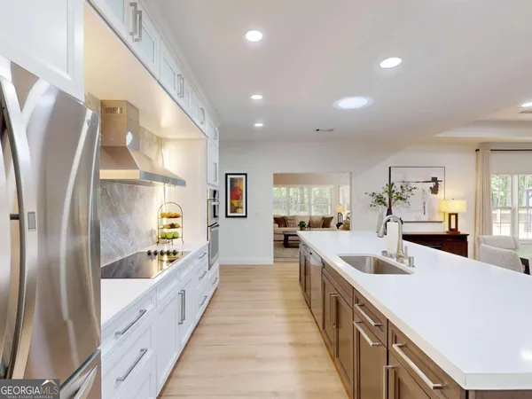 a large kitchen with stainless steel appliances a sink and cabinets