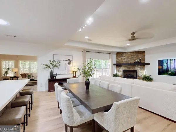 a dining room with furniture a rug and a kitchen view