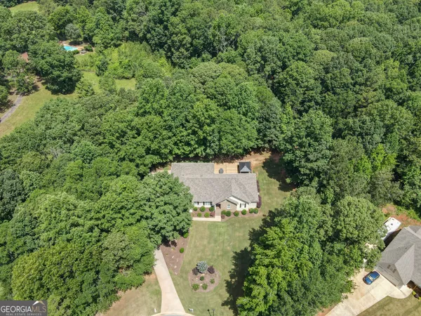 an aerial view of a house with swimming pool and garden