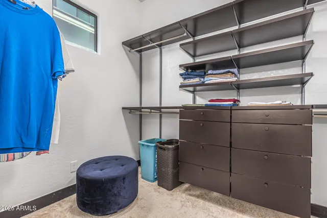 a spacious bedroom with a bed a mirror on dresser and a flat screen tv