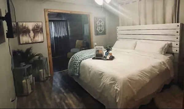 a bedroom with a bed and wooden floor