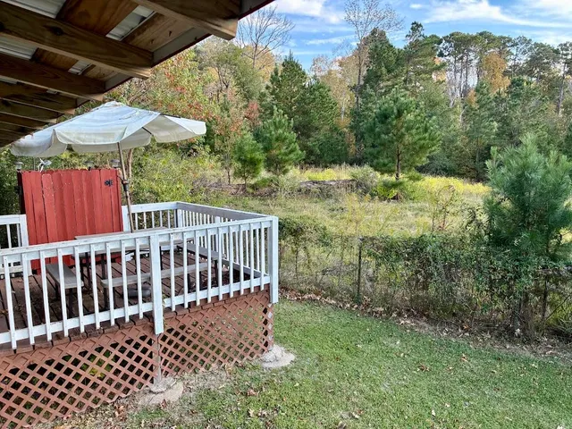 a view of a backyard with a small deck and a garden