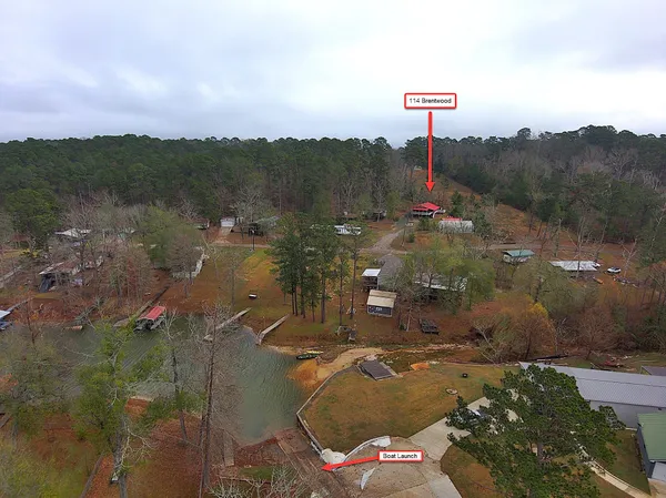 an aerial view of a house with a yard lake and mountain view in back