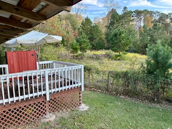 a view of a backyard with a small deck and a garden