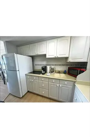 a kitchen with a sink a refrigerator and cabinets