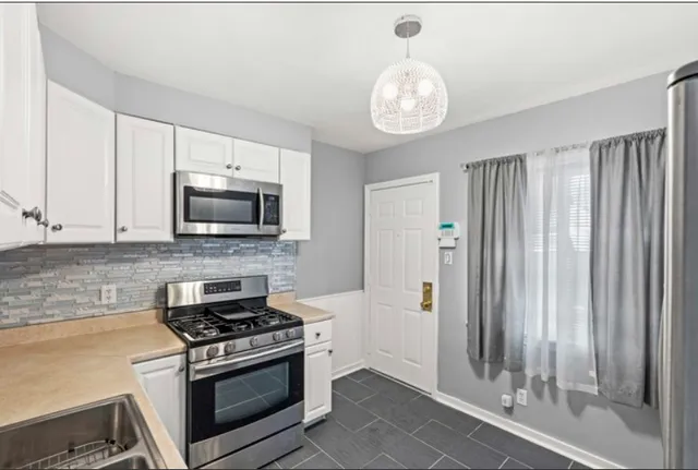 a kitchen with stainless steel appliances granite countertop a stove and a microwave