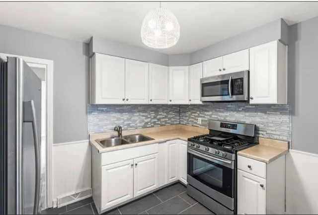 a kitchen with cabinets stainless steel appliances and a counter space