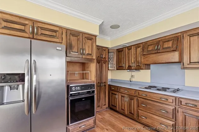 a kitchen with stainless steel appliances granite countertop a refrigerator and a stove top oven