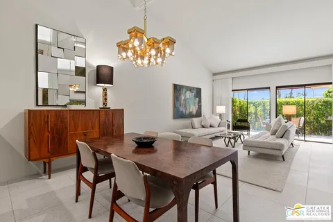 a view of a dining room with furniture a livingroom and chandelier
