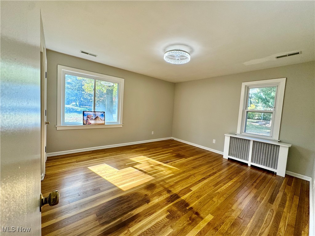 1729 East Pleasant Valley Road Independence, OH 44131 - Photo 21 of 41 Unfurnished room with hardwood / wood-style floors, a healthy amount of sunlight, and radiator
