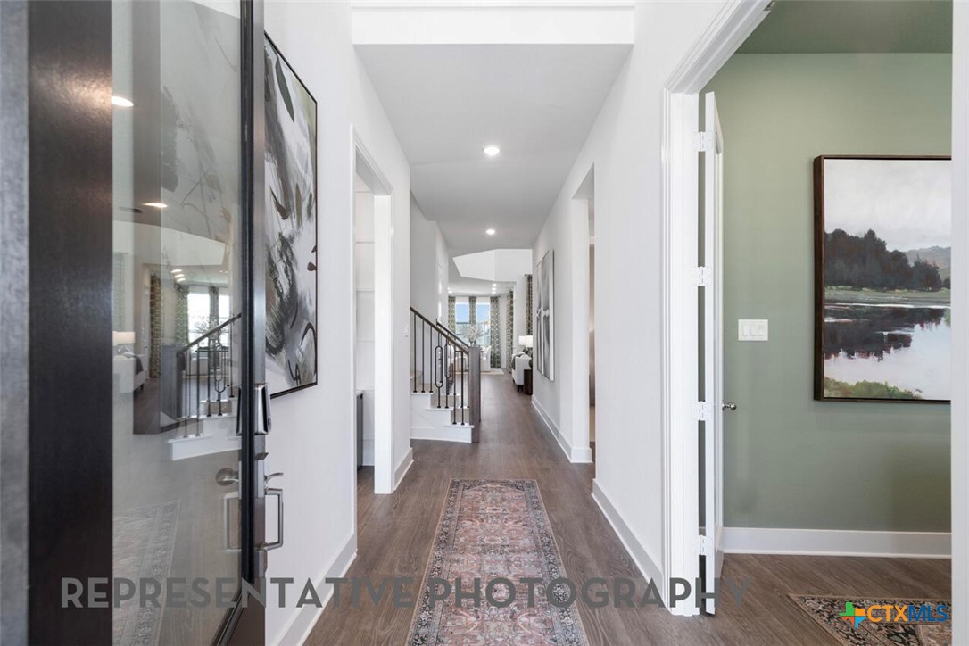 511 Fawn Ridge Cibolo, TX 78108 - Photo 15 of 22 a view of a hallway with wooden floor and staircase