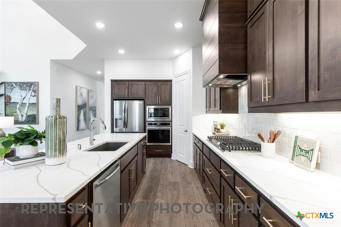 511 Fawn Ridge Cibolo, TX 78108 - Photo 4 of 22 a kitchen with granite countertop a sink a counter space stainless steel appliances and cabinets