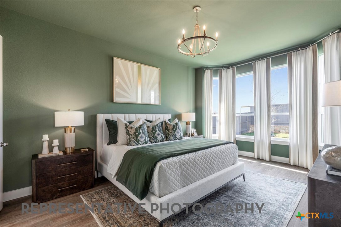511 Fawn Ridge Cibolo, TX 78108 - Photo 9 of 22 a bedroom with a large bed and a chandelier