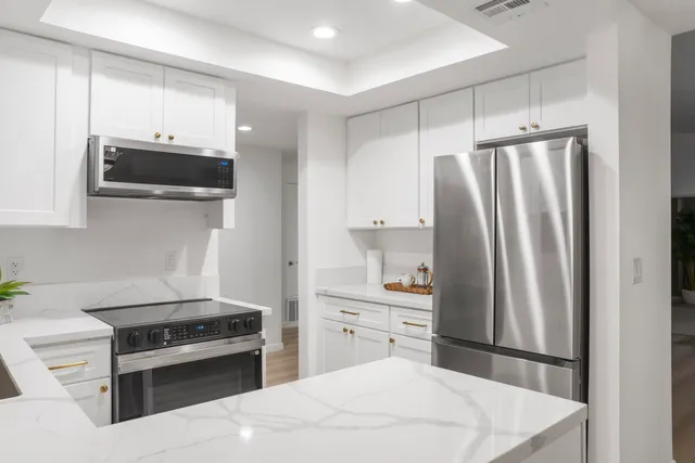 a kitchen with stainless steel appliances a stove a refrigerator and a sink