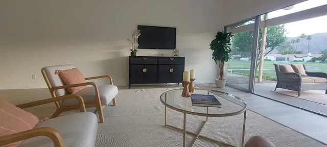 a living room with furniture and a floor to ceiling window