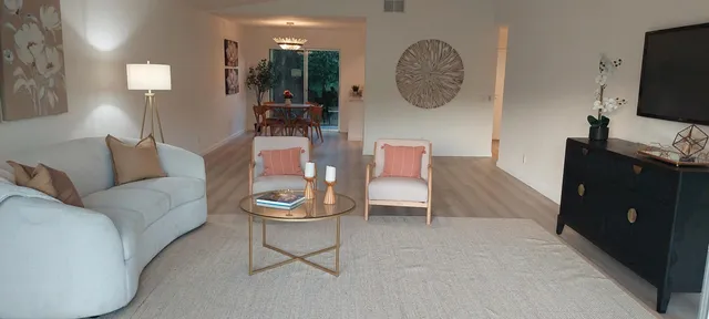 a living room with furniture a flat screen tv and a clock