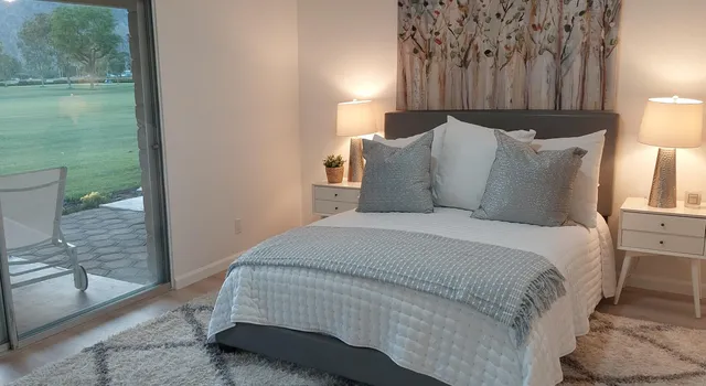 a bed sitting in a bedroom next to a window with a balcony