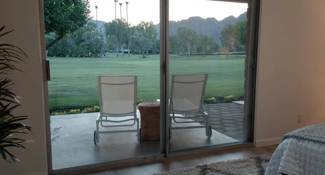 a view of a porch with a table chairs and a yard