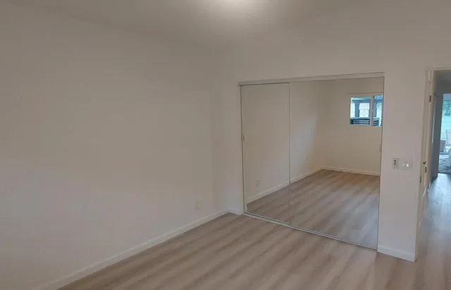 a view of an empty room with wooden floor