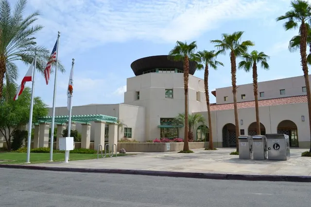 a view of multiple houses with a yard and palm trees