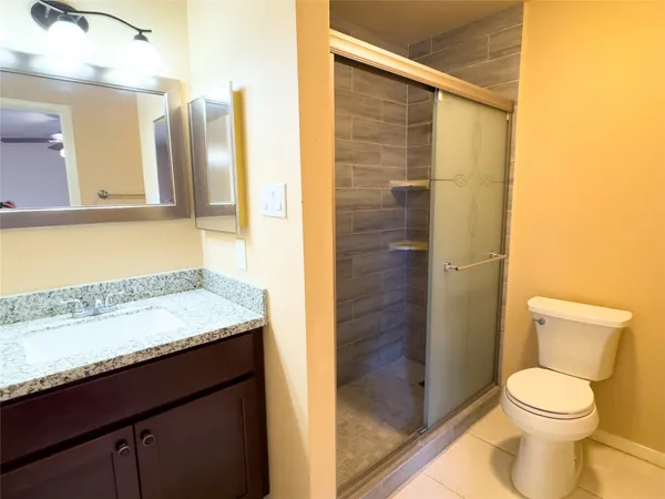 a bathroom with a granite countertop sink toilet and shower