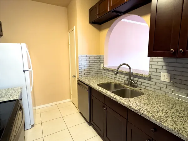 a kitchen with a sink a refrigerator and cabinets
