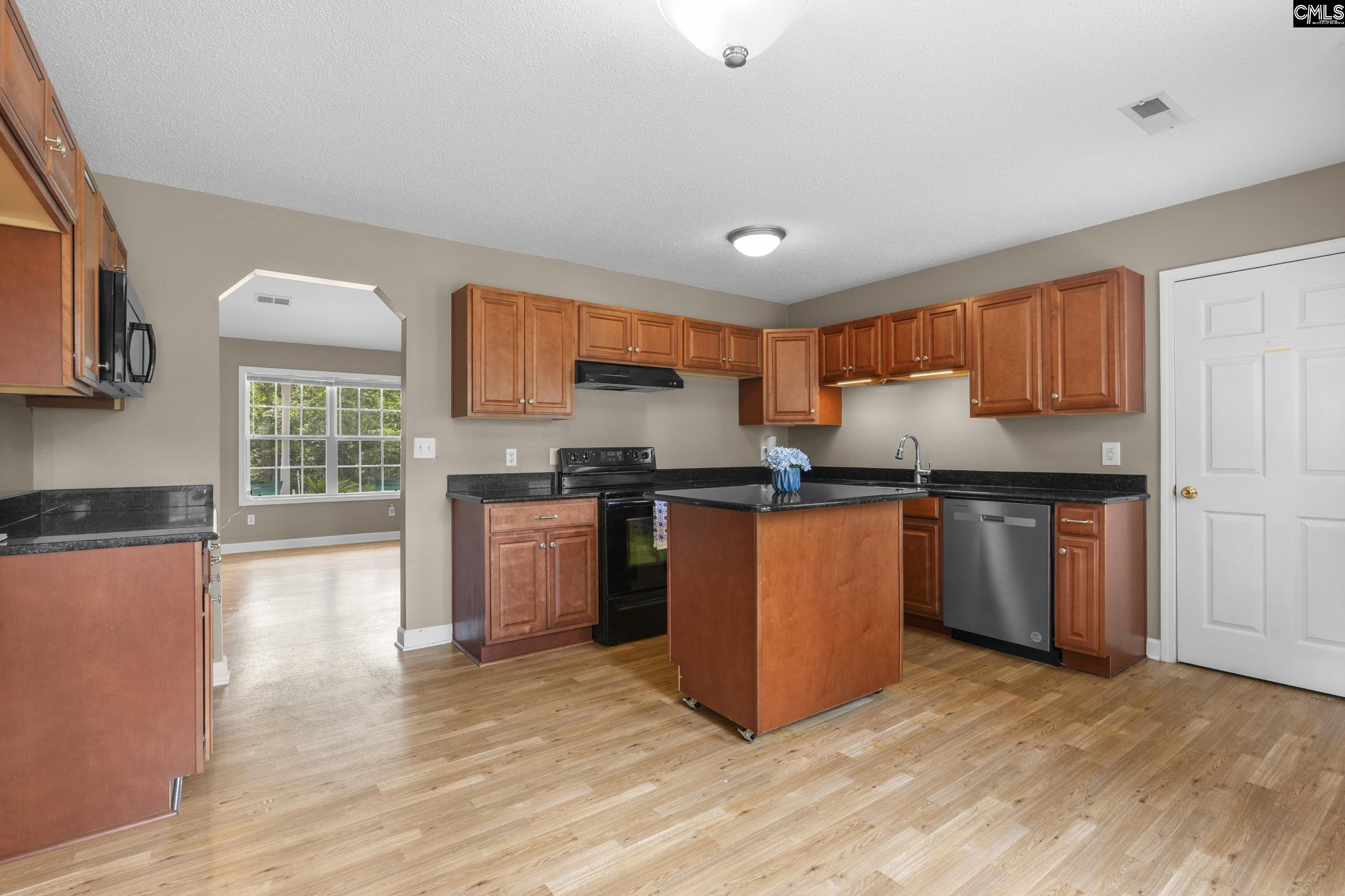 548 Eskie Dixon Road Elgin, SC 29045 - Photo 11 of 27 a kitchen with granite countertop wooden floors a stove and a refrigerator