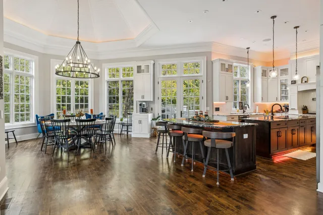 a view of a dining room and livingroom with furniture wooden floor a chandelier
