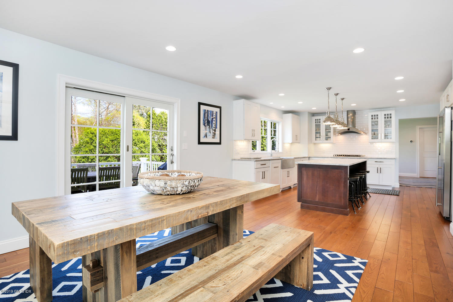 35 Chapel Lane Riverside, CT 06878 - Photo 13 of 45 a kitchen with kitchen island a stove and a table chairs in it