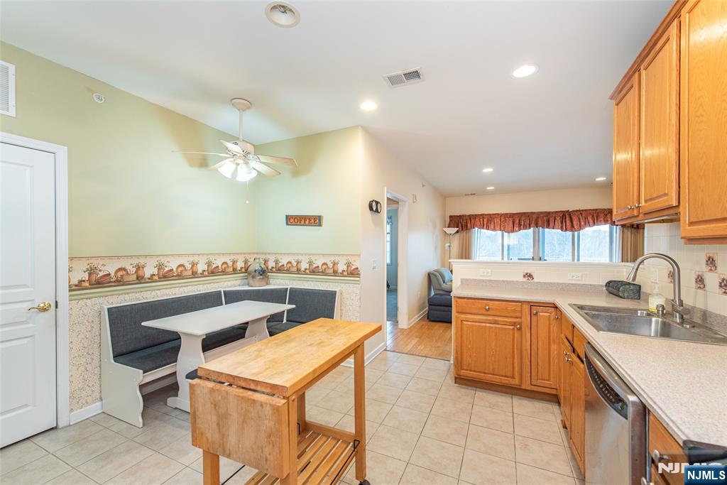 10323 Warrens Way Wanaque, NJ 07465 - Photo 13 of 30 a kitchen with a sink a stove and chairs