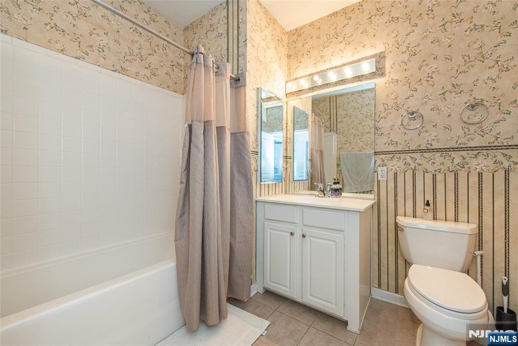 10323 Warrens Way Wanaque, NJ 07465 - Photo 18 of 30 a bathroom with a granite countertop toilet a sink and a bathtub